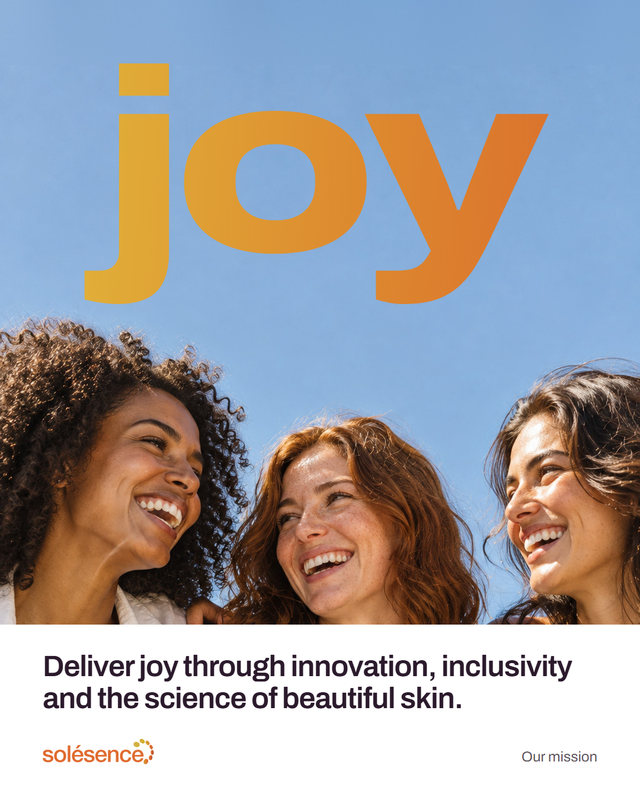New concept post. Three friends laugh together under a blue sky; the word joy, huge in gold and orange, wraps round them. Below: Deliver joy through innovation, inclusivity and the science of beautiful skin. Our mission.